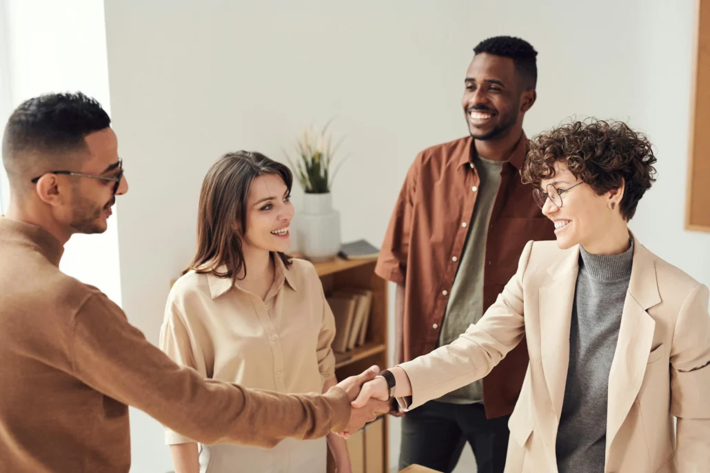 Profesionales estrechando manos y conversando en un entorno colaborativo, representando el networking en el Global Executive MBA de Euncet Business School.