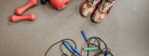 Elementos deportivos como zapatillas, pesas y cuerda en el suelo, representando cómo se llama INEF ahora y sus alternativas académicas.