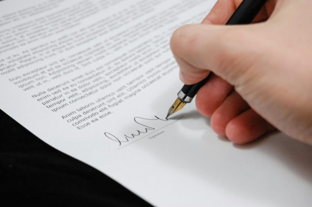 Persona firmando un documento con pluma estilográfica.